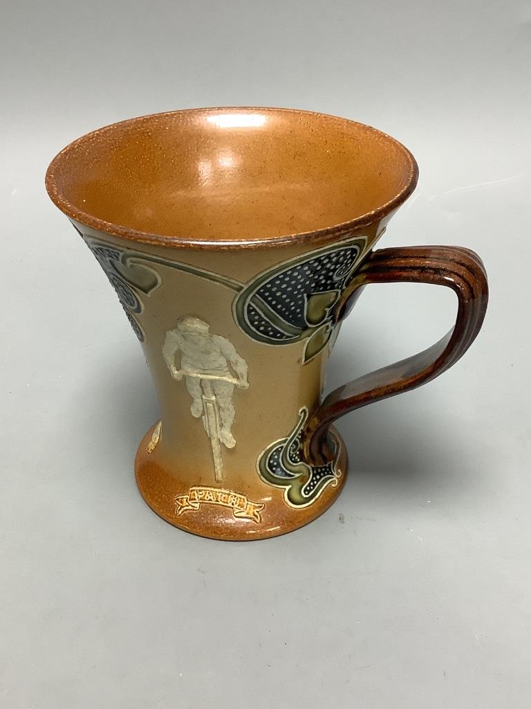 A Doulton Lambeth cycling related stoneware mug, c. 1900, height 12cm